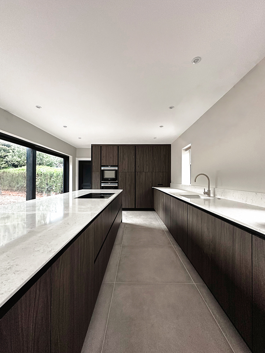 Stunning dark wood kitchen with large kitchen island. Kitchen extension in Coventry with Bora hob and wood texture. Bespoke Italian Luxury kitchen